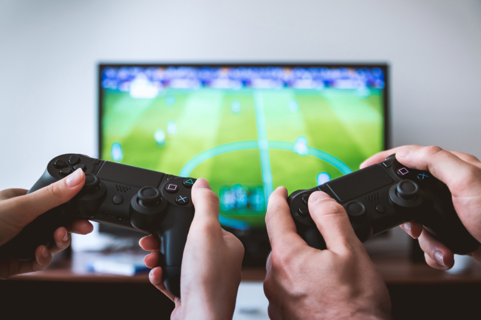 ゲームコントローラーで遊ぶ人物